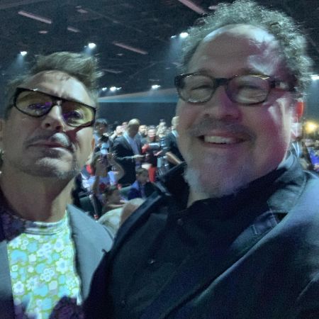 Jon Favreau is taking a selfie as Robert Downey Jr. looks on.